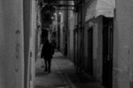 A suspect hurrying away from the camera down an alley