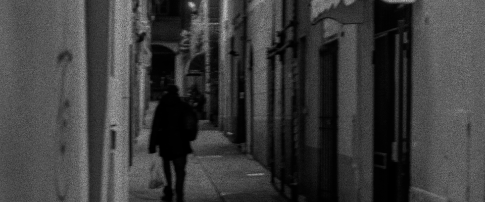 A suspect hurrying away from the camera down an alley