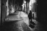 Two blurry figures stand in a empty street